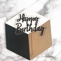 Detail of Happy Birthday acrylic cake topper with gold glitter stem on marble background - Black