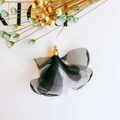 Macro shot of black and white chiffon petal tassels with golden metal caps for DIY jewelry - Black and White
