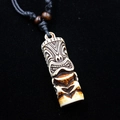 Close-up of Tiki totem pendant with bone-like texture and black woven rope detail - Style A / Brown