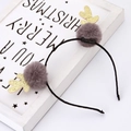 Detail of Christmas reindeer headband with gold sequins and plush balls on a festive background - Brown Pompom Antler Headband