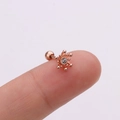 Détail d'une boucle d'oreille étoile en or rose avec une pierre en cristal - Design Étoilé / Or rose