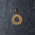 Detailed macro view of a gold-plated titanium circular pendant with Hebrew engraving - H04 Sanskrit Circle