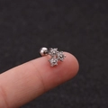 Macro view of a stainless steel flower ear stud with zircon details held on a fingertip - Triple Petal Flower Zirconia Style (HSPJ1915-7#)