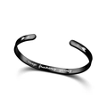 Detailed macro view of black titanium steel cuff bracelet with motivational engraving - Engraved Version / Black