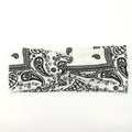 Détail d'un bandeau blanc torsadé avec un motif classique paisley noir tricoté - Blanc