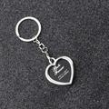 Macro shot of silver heart photo frame keychain with dimensions on black background - Heart Locket
