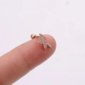 Vue macro d'une boucle d'oreille éclair en or rose avec incrustation de zircons brillants - Éclair / Or rose