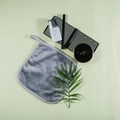 Grey microfiber makeup remover pad with hanging loop on a soft green background - Gray