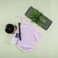 Purple microfiber facial cleansing towel with pink trim and hanging loop on green background - Purple