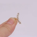 Close-up of golden curved ear stud with clear zircon flowers worn on earlobe - Gold Curved Row Zircon Style (金色4#)