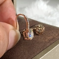 Dettaglio macro di orecchini pendenti in oro rosa con grande zircone tondo e pavé - Oro rosa