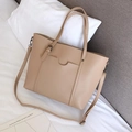 Close-up of beige PU leather tote bag with crescent-shaped pocket and adjustable strap - Khaki