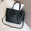 Detail of minimalist black PU leather tote bag with lychee texture and silver hardware - Black