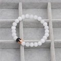 Detail of beaded crown bracelet with black matte beads and rose gold crown on velvet - White Cat Eye