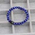 Macro view of blue cat eye stone beads and silver micro-pave crown charm on a bracelet - Sapphire Blue