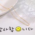 Polished 18K rose gold plated stainless steel O-chain necklace on a white ceramic dish - O Chain / Gold