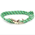Macro detail of green woven rope bracelet featuring a golden shark shaped metal buckle clasp - GSY-05 Green Yellow Black Rope + Gold Shark Hook