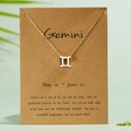 Golden Gemini zodiac sign necklace featuring rhinestones on a descriptive paper card - Gemini / Gold