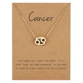 Detailed view of golden Cancer zodiac necklace on a kraft gift card with personality description - Cancer / Gold