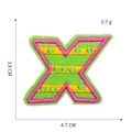 Detailed embroidery texture of pink and yellow letter X patch on neon green base - Letter X