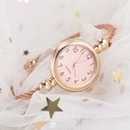Close-up of rose gold cuff watch featuring a pink dial and twisted cable band design - Arabic Numerals Rose Gold Band Pink Dial