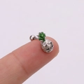 Detailed close-up of a silver pineapple stud earring with crystals on a fingertip - Pineapple / Silver