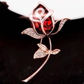 Close-up of rose gold flower brooch with ruby red stone and sparkling pavé crystals - Red Rose