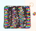 Detail van omkeerbare pailletten en een gouden sleutelhanger aan een make-uptasje - Regenboog