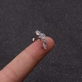 Macro detail of curved ear cartilage stud with white zircon crystals held by hand - Curved Marquise Style (6#)