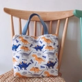 Detail des Dinosaurier-Aufdrucks auf Baumwolltasche mit blauen Webgriffen - Dinosaurier