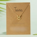 Golden Taurus zodiac symbol necklace with rhinestone on a creative paper card holder - Taurus / Gold