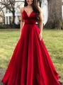 Détail d'une robe de soirée en satin rouge avec décolleté en V élégant et texture en soie - Rouge