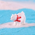 Miniature polar bear figurine with a red scarf on blue sand winter background - Polar Bear with Red Scarf