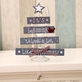 Grey wooden Christmas tree hanging decor with bells, plaid bow, and holiday greeting - Grey