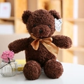 Oso de peluche marrón con cinta dorada Love y etiqueta de marca en ambiente acogedor - Oso Con Lazo Marrón Oscuro