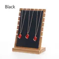 Detail of three teardrop ruby necklaces on a wooden display stand with black padding - Black Leather / Large Detachable / Black