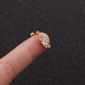 Detailed view of a gold star stud earring with zircons held by fingers to show scale - Star Combination Design (6#)