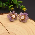 Floral pearl earrings featuring purple crystal petals and gold accents on wood - Amethyst