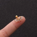 Makroaufnahme von Gold-Ohrstecker mit fünf Markise-Zirkonia auf einer Fingerspitze - 5-Stein-Bogen-Stil (No.18 Gold) / 1.2x6mm (Stabdicke x Länge)