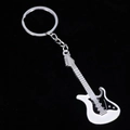Detalle de un llavero de guitarra eléctrica creativo en blanco y negro sobre fondo oscuro - Blanco