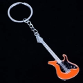 Detalle de llavero de guitarra naranja y negro con acabado metálico sobre fondo negro liso - Naranja