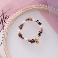 Detail view of handmade beaded bracelet with pearls, gemstones, and vintage coin charm - Colorful