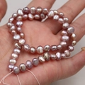 Natural lavender baroque freshwater pearls strand held in hand for DIY jewelry making - Natural Purple
