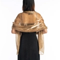 Rear view of an elegant sheer gold shawl with a glossy finish draped over black dress - Camel