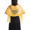 Detailed view of glossy gold translucent shawl draped over a black evening dress - Yellow