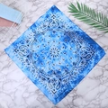 Close-up of blue paisley 100% cotton bandana showing detailed patterns on marble surface - One Size / Blue