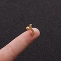 Macro shot of gold S-curve stud earring with micro-pave zircons held on a fingertip - 3# (S-Shape) / Gold