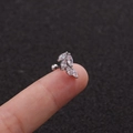 Makroaufnahme von Blatt-Ohrstecker aus Edelstahl mit Zirkonia auf einer Fingerspitze - Miniatur-Blattkombination (2#) / Silber