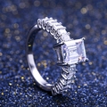 Gros plan d'une bague en zircone taille émeraude sur fond bleu scintillant de luxe - US 8 / Argenté