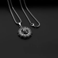 Detailed macro view of a silver titanium skull pendant with Roman numeral clock detailing - Digital Skull + Stainless Steel Chain